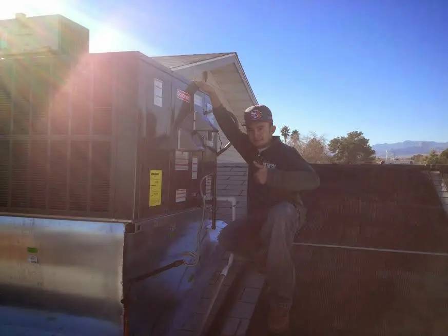 HVAC technician performing Air Duct Cleaning on a rooftop unit in Collinsville