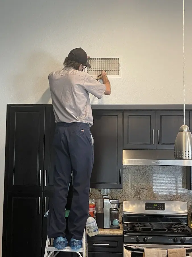 Technician inspecting an air vent during HVAC service in Collinsville